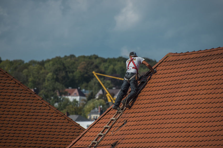 Couvreur réparant un toit en tuile - entreprise de couverture Elie couverture 78
